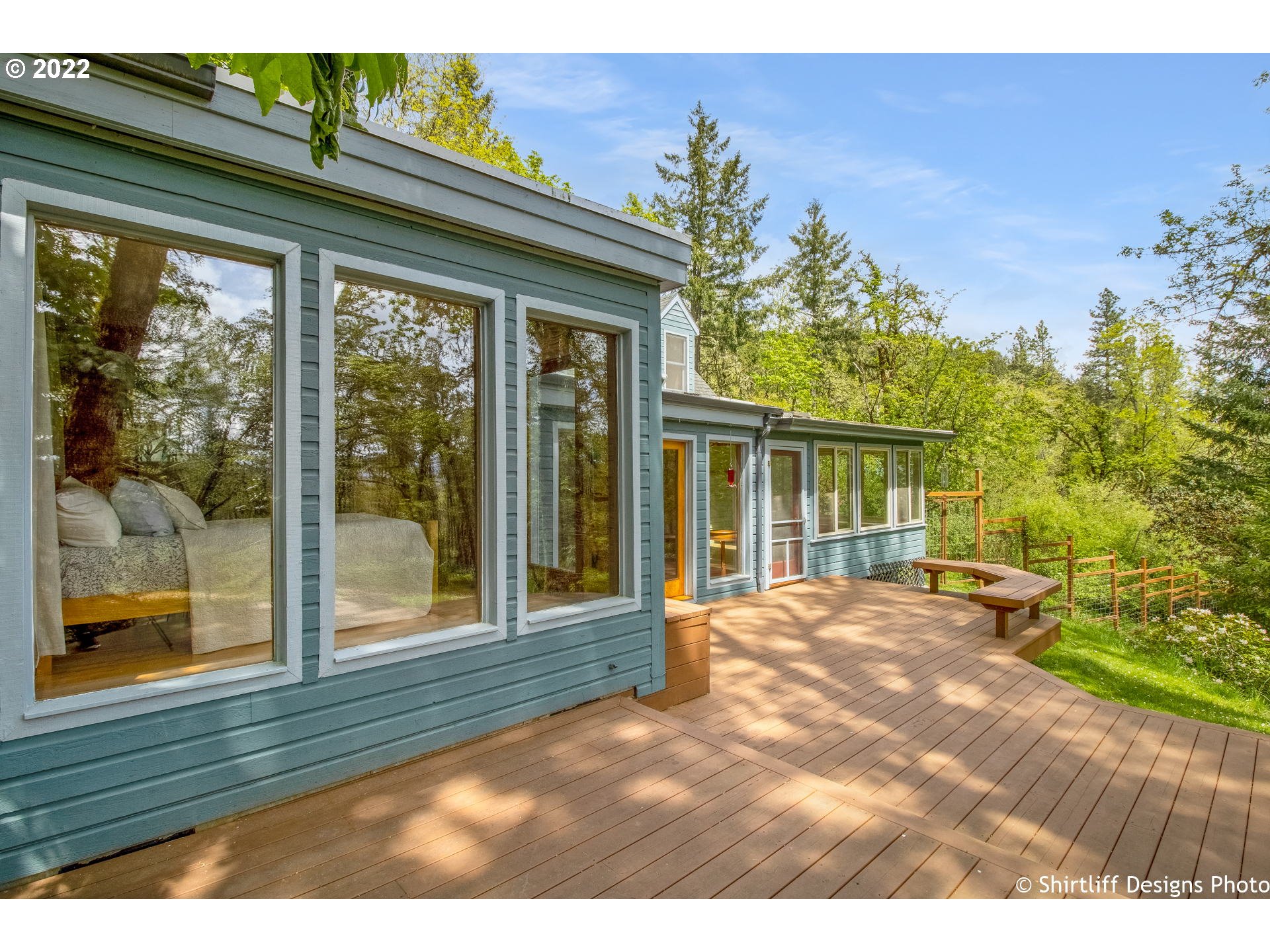 Tranquil close-in country private oasis with seasonal creek and 2 story guest/studio/shop and storage. This lovely home offers unique wood flooring & tasteful wood tongue-n-groove walls, granite counters, office w/ south facing passive solar windows to  expansive deck, sunroom & main level primary suite w/ remodeled bathroom incl. heated floors & towel rack. Upstairs are two bedrooms and full bath w/ clawfoot tub. Gorgeous fenced and terraced south-east facing yard & garden w/ ample sunlight!