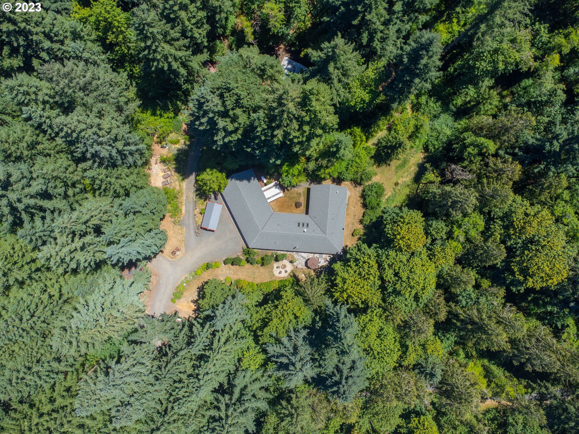 Experience true privacy and peaceful living in the forest very close-by the Mckenzie River. This one story home boasts a generous layout with tons of storage, nestled on a sprawling 4.5-acre lot encircled by majestic trees. This completely versatile home is  true entertainer's delight, offering 4 beds, 3 baths, and multiple outdoor spaces. Vaulted ceilings and abundant natural light create an inviting ambiance around the clock. Revel in ultimate seclusion just 10 minutes from town. Luxurious owners' suite features a private patio, oversized shower for two, and soaking tub. The chef's kitchen flaunts a Blue Star 60-inch gas range with a 24-inch griddle, extensive granite counters, and a walk-in pantry. Immerse yourself in nature through windows, sliders, the flagstone patio, walking paths, and the seasonal creek. There is an additional finished room attached to the homes exterior that would make a wonderful art space, private office, or room to expand primary. Storage barn, wood shed, poultry coup, and extra storage structures are included. With a 858sqft garage, RV space, and more, this rare gem is not to be missed. Fiber optic at the street, spectrum internet service 1,000mbps. Don't miss the property video! Schedule a showing today!