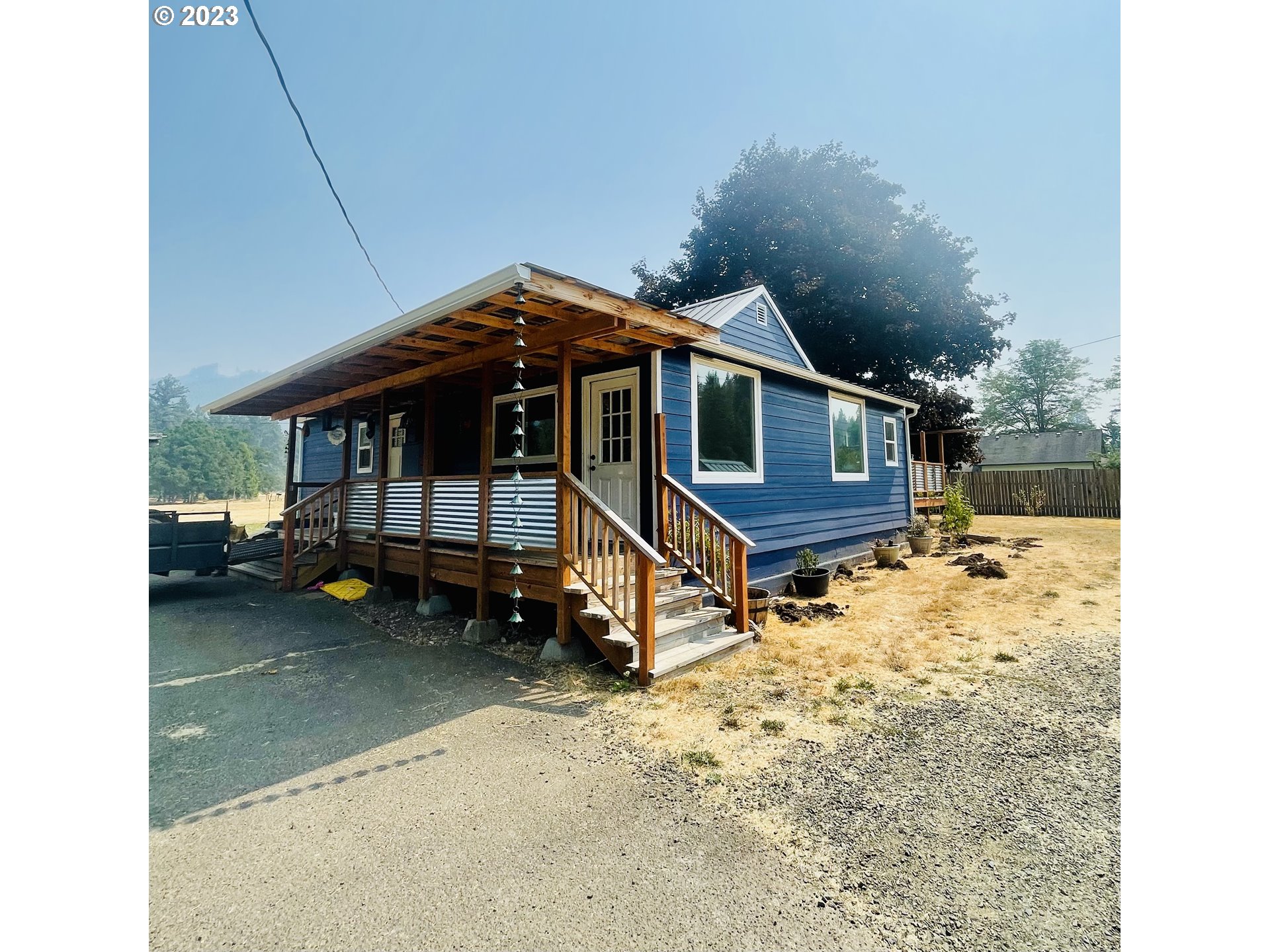Adorable bungalow ready for your finishing touches! Stunning views, big shop and 2 stall barn, fully fenced on almost 3 acres! New windows, siding, flooring, electrical with dual decks and a metal roof. Primary bedroom is an oversized oasis with sitting area, views and lovely deck overlooking property. So many options with this mini ranch to have a sweet slice of land, maybe build your dream home in back of property and put the in laws up front?! Or relax and enjoy a small farm with privacy and great views! Plenty of shop space to tinker and great water flow to grow!