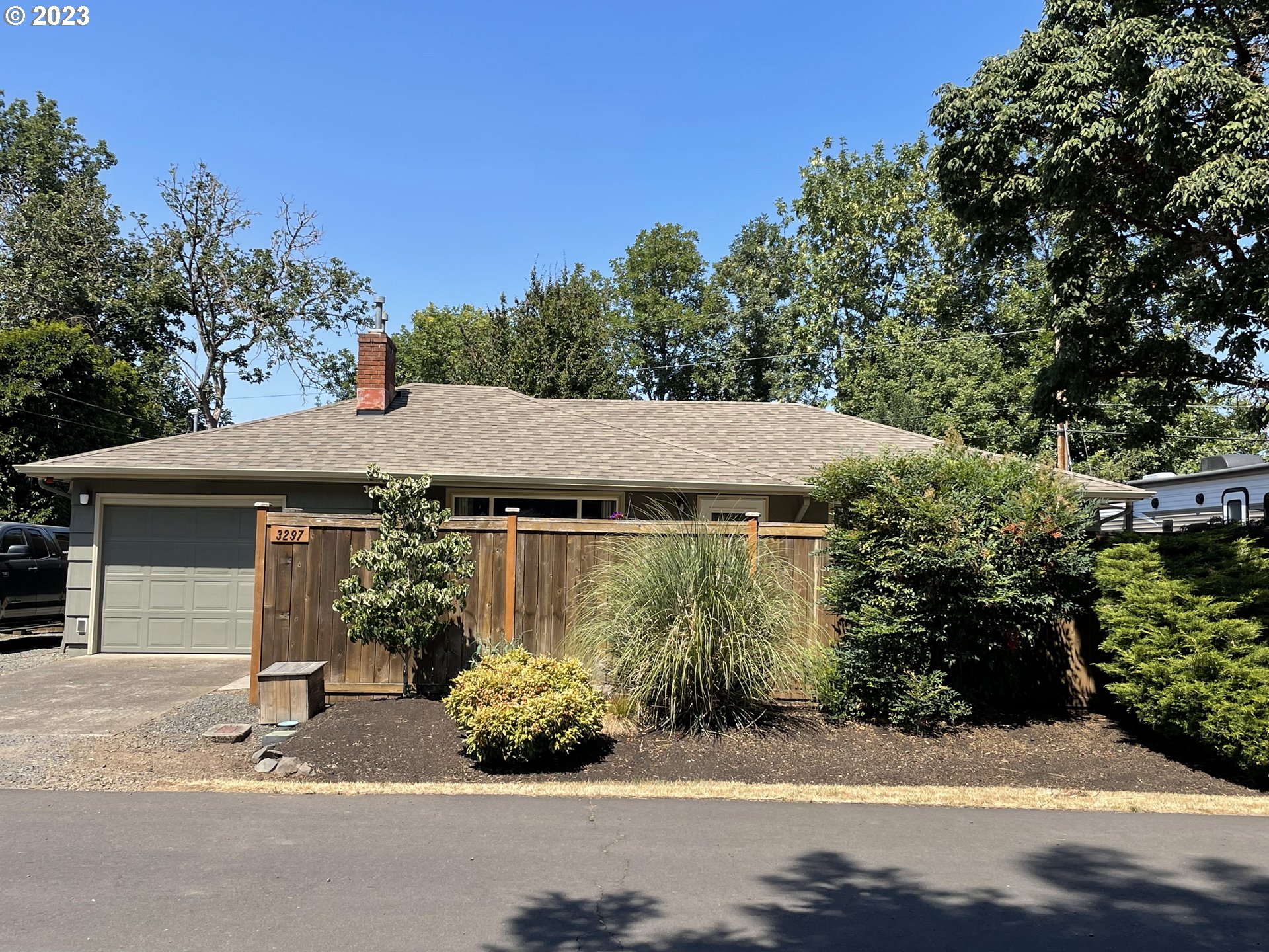 Updated and maintained impeccably, and move-in ready!! Functions like a larger home. The hardwood floors and gas fireplace add touches of warmth. You will enjoy cooking in the stylishly remodeled kitchen with quartz counters, stainless steel appliances, pantry cabinet, and view of the garden that has raised beds, strawberries & blueberries, espaliered apples with 4 varieties, and full irrigation. The bathroom has been completely remodeled and offers a contemporary barn door entrance, dual shower heads, cultured marble shower surround and counter, updated lighting, and tile floors. Laundry area includes stackable washer/dryer and the addition of a laundry sink. One of the highlights of the home is a stunning covered deck that creates a pleasant outdoor room for year-round use. Beautiful wood built-ins and new bay window are featured in the dining area. Additional amenities include: newer exterior paint and hot tub, vinyl windows, RV parking with all hookups, 20x20 heated, detached garage/shop, forced air gas furnace and central A/C, roof replaced approx. 2010,  motion sensor exterior lights, and private front patio. This is a rare find of a property that has a gorgeous interior, driveway space for numerous vehicles, 2 gated parking areas for RV and other toys, ample storage, light and bright, heated shop with potential for hobbies, dedicated home office for remote work, gym, art studio, and neatly landscaped areas for gardening and for play. This property is also fully fenced. All of this on a corner lot with potential for future expansion or ADU. Location convenient to Oakway Mall, eateries, Autzen Stadium, Gateway Mall, hospital, and freeway access.