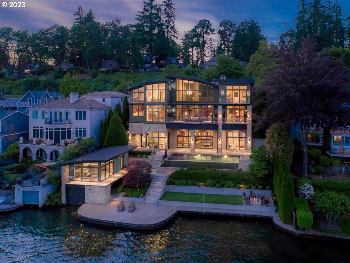 Iconic Oswego Lake Front Contemporary-the one that everyone admires when they pass by. True to the "Live Where You Play" mantra this spectacular piece of art was built to stand the test of time in both quality and style. This home could not be rebuilt today with todays height restrictions, the sheer volume is inspiring. Soaring ceilings on every level, walls of glass to soak in that southern exposure, lakeside pool and rare guest studio over the boat house. Situated on a double lot this home takes advantage of everything Lake. Sophisticated yet comfortable with a floor plan that fits many lifestyles. The images and video  speak for themselves, but it's even better to experience in person!