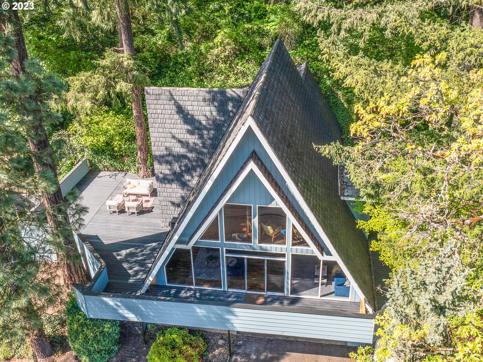 Architecturally stunning A-Frame that tickles the trees of Rocky Butte amplifying authenticity. Respectfully remodeled paying homage to the chalet. Upstanding updates w/period like finishes. Spectacular southern views w/peaks of Downton Portland from the expansive wall of windows and wrap around 1,000+ sqft deck. Beamed Ceilings, stunning skylights, walls of windows, wonderful wood paneling, handsome hardwoods. Sexy staircase and lovely loft. The layout allows for 2 separate living spaces w/3 bed/2 bath upstairs & 1 bed/1 bath w/ full kitchen in downstairs daylight basement. ADU received rents upwards of $2,300 this past year. Main home has rented for $4000-$4400/month. Built by local Architect William Wayman for himself.