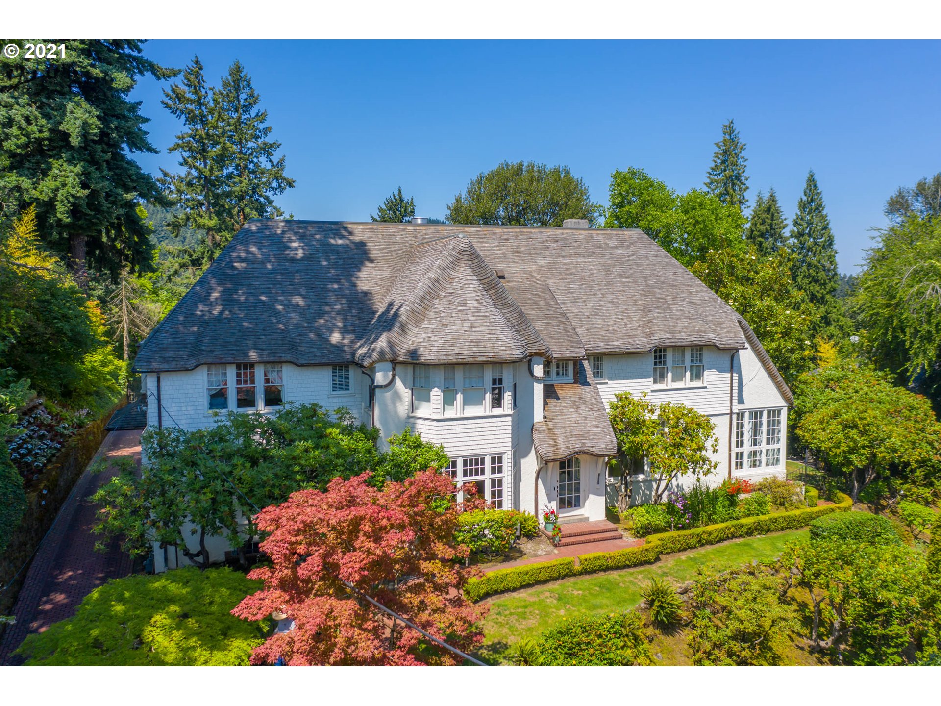 OPEN 9/26 TUESDAY FROM 12-2PM. On an amazing street of exceptionally well-designed residential architecture, sits proudly the very typical English Cottage design by A.E. Doyle.  Offering panoramic views, the house sits high on a ridge above SW Montgomery.  The home with its lengthy driveway offers privacy and garage.  The home's exterior has English Cottage rolled eaves, as well as rolled ridges on its newer wood shake roof. Stucco combines with shingle siding and river rock on its distinctive exterior.  The interiors are relaxed and inviting, with the welcoming grand staircase, multiple wood burning fireplaces, and warm wood trim.  All rooms enjoy spectacular views of the city to the East or the terraced hillside gardens to the West.  Owner's suite consists of several rooms facing the city side that include bedroom, bath, dressing room & writing room with fireplace.  Kitchen features multiple rooms for cooking, casual dining,  spacious butler's pantry, & home office. Walking distance to popular Alphabet district for shopping and dining, STEM program schools and parks.