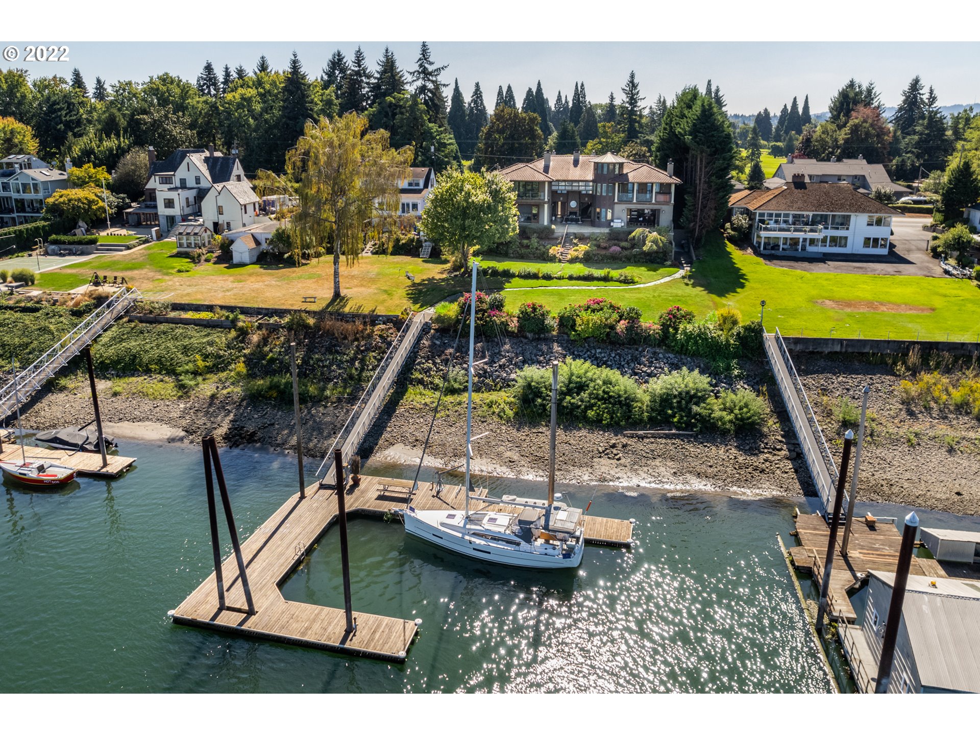 Custom built, steel framed 5 Beds/5.5 Baths. 6310 SqFt of Living Space, 2380sqft of Garage/Shop w/heated, epoxy floors & built-in cabinets. Side roll-up garage door for easy access to lawn & boating equipment storage. 2 EV car charger outlets. Steel enforced boat dock can accommodate 60-foot yacht plus multiple smaller boats & water toys. Includes 1,500 lbs crane lift, water, power, WiFi cable TV & house phone lines at dock. Two 50 amp/250 volts hookups for powering yachts. Dock rope light, 75-foot ramp with LED lights. Elevator access for 3 levels of living. Chefs kitchen w/twin Wolf gas/convection ovens, Wolf 6 burner 16k BTU gas cooktop w/griddle and pot filler, full size Sub-Zero refrigerator, warmer drawer, twin Bosch stainless steel dishwashers, prep sink w/disposal, pull-out garbage & recycle bins, large, air-conditioned pantry. Heated slate floors. Folding glass accordion wall system extends 850 square feet connecting the greatroom to outdoor living. Quarter sawn solid cherry wood cabinets. Main floor laundry/mud/prep room w/refrigerator/freezer, full bath, and side access doors. Outdoor/Indoor living space w/striking wood fireplace w/pounded iron custom surround, floating wood mantel and 20ft glass roll up door. Media/Game room w/custom Bathos Studios glass bar w/marble counters, Sub-Zero under-counter fridge/freezer, sink w/disposal, Bosch dishwasher, gas fireplace & heated, distressed wood floors. Primary suite glass tile spa bath w/Mr. Steam shower, heated travertine floors & under vanity lighting. Marble countered dual vanity w/heated mirrors. Coffee/bar nook w/Sub-Zero under-counter frige/freezer. Reinforced steel deck off primary bath w/private hot tub, 400sqft closet w/built-in island dresser, cedar lining & washer/dryer. High-end rollout out Milgard windows throughout. 50-year tile roof. Custom hallway chandelier that lowers to the floor level for cleaning. Lutron quiet & remote-controlled blackout shades. Terraced landscaping w/sprinklers & more. [Home Energy Score = 3. HES Report at https://rpt.greenbuildingregistry.com/hes/OR10041133]