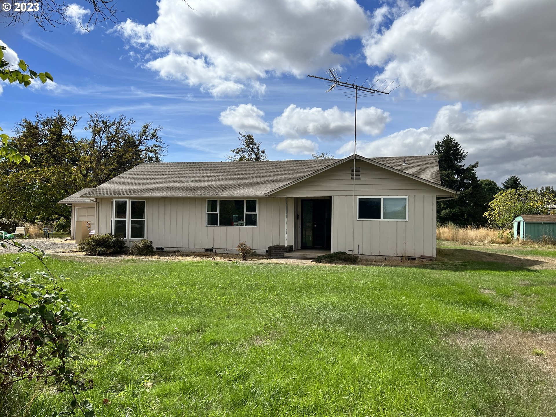 Amazing opportunity to own this 4+ acre property and home on a dead end street just 3 miles from City limits. This home is 1500+ square feet and offers 2 bedrooms and 2 baths. The big country kitchen has SO much storage and a slider to the covered patio. There is a  2 car garage that has a ton of built in storage cabinets and there is a 2 story shop for all your toys. This fully fenced and gated property also has an RV garage for more toys and could easily be converted to a barn for animals. Fruit trees, 2 varieties of grapes, a walnut tree and 2 fig trees are fully mature and will be loaded with goodness in the summers! If you are in need of a hardship residence, it had one in the past and the utilities are in place. Level useable pasture gives you room to roam. Come make this home your own!
