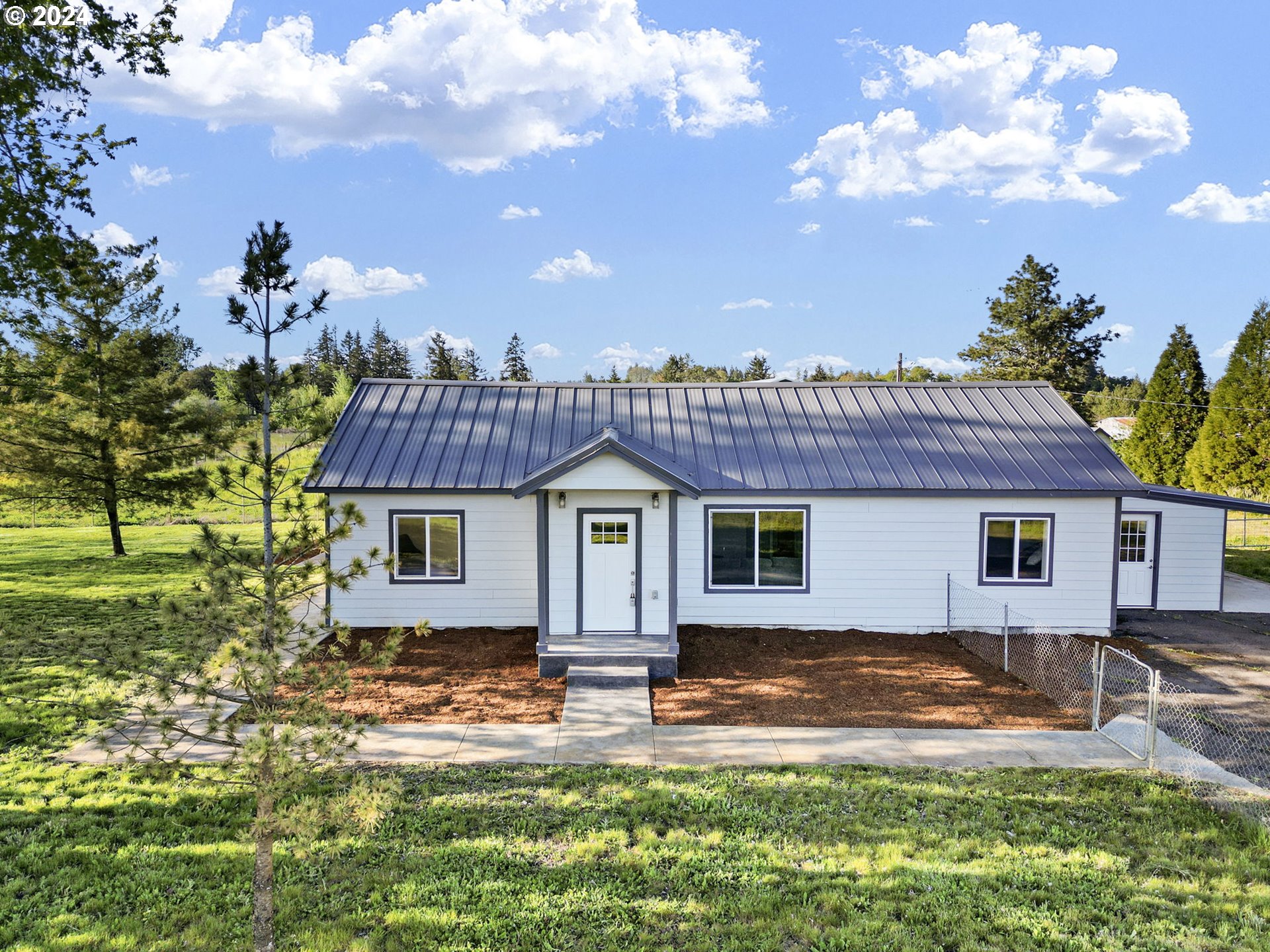 Quaint farm house that has been beautifully remodeled. This turnkey home has a new metal roof, windows, flooring, fiber cement siding, plumbing and ductless heat pump system with a head in each room for maximum comfort and efficiency. The kitchen boasts new cabinets, counters, a beautiful farm sink, tile back splash, stainless steel appliances. Enjoy beautiful views on the new stamped concrete covered patio. The barn includes 6 stalls, tack room and riding arena. Small workshop attached to home plus carport. Small paddock on sleds can easily be moved to provide greater "free range" for animals. Fenced in yard around the home plus pasture is cross fenced. Plenty of room for all your toys and animals. Two wells service the property - one for the barn and one for the home.