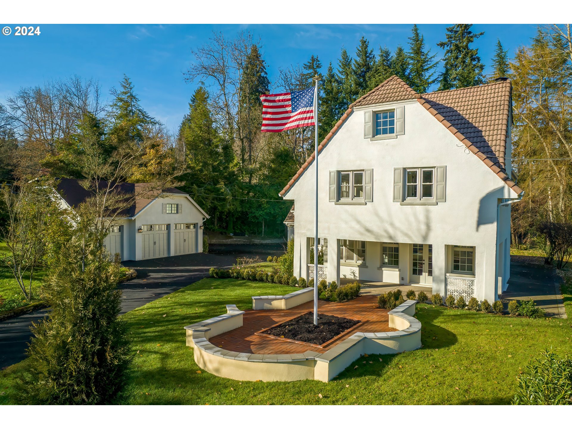 This exquisitely revitalized English Cottage-style residence in Lake Oswego's Glenmorrie neighborhood seamlessly blends historic charm with modern luxury. Originally designed in 1918 by Sutton & Whitney and meticulously refreshed by designer Phil Chek, this 106-year-old home sits on half an acre of land. The interior features a layout perfectly suited for entertaining with new, imported French oak hardwood floors and freshly painted white walls. The home seamlessly integrates indoor/outdoor living, with the living room leading to a covered patio, the dining room providing a connection to the backyard, and a well-appointed kitchen featuring quartz countertops and a charming wood-burning stove. The basement, with a unique history as part of the original ranch reservoir, serves as additional storage. A guest or nanny quarters, a newly-built three-car garage, and a century-old legacy make this timeless architectural icon an exceptional property.