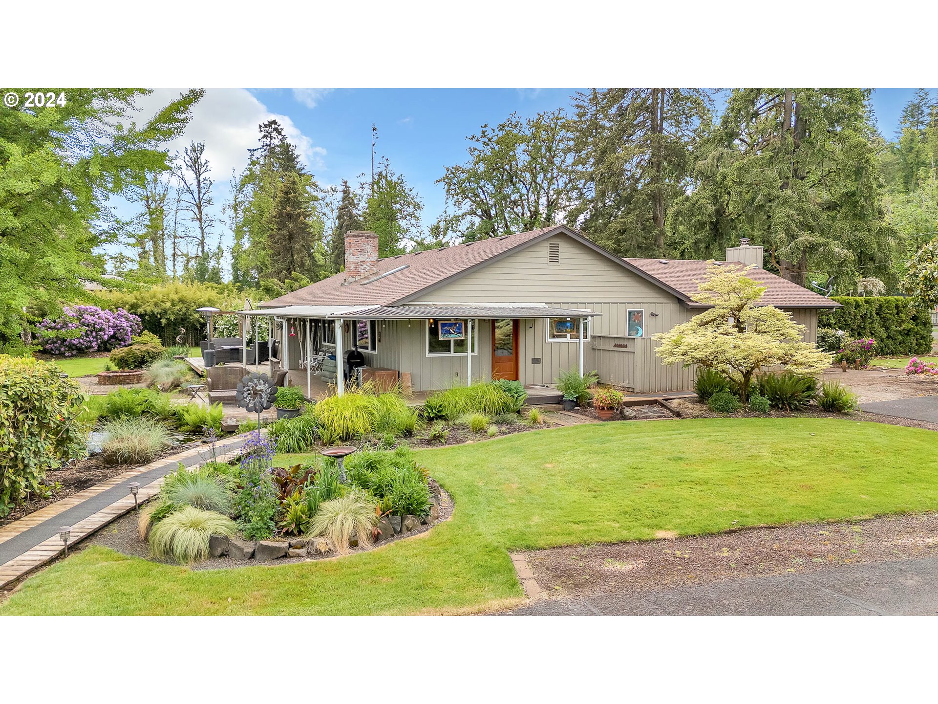 Escape to tranquility on this flat, usable 2.5-acre property, with 2 acres of water rights for irrigation. Step inside the meticulously maintained home featuring a cozy living room with a fireplace, and a spacious family room with a pellet stove. Retreat to the master suite offering its own fireplace and a heated tile bath. The newly remodeled kitchen has granite countertops, new cabinets, stainless steel appliances and a pantry.Outside, discover a range of amenities including a barn, shop with an office, an orchard with several fruit trees, a greenhouse for gardening and the 60x80 outdoor arena makes this a great horse property. Relax on the deck by the koi pond, surrounded by gated, fenced land that is beautifully landscaped providing privacy and space for all your recreational activities. Experience the perfect blend of rustic charm and modern luxury in this countryside retreat. This is truly a one of a kind property.