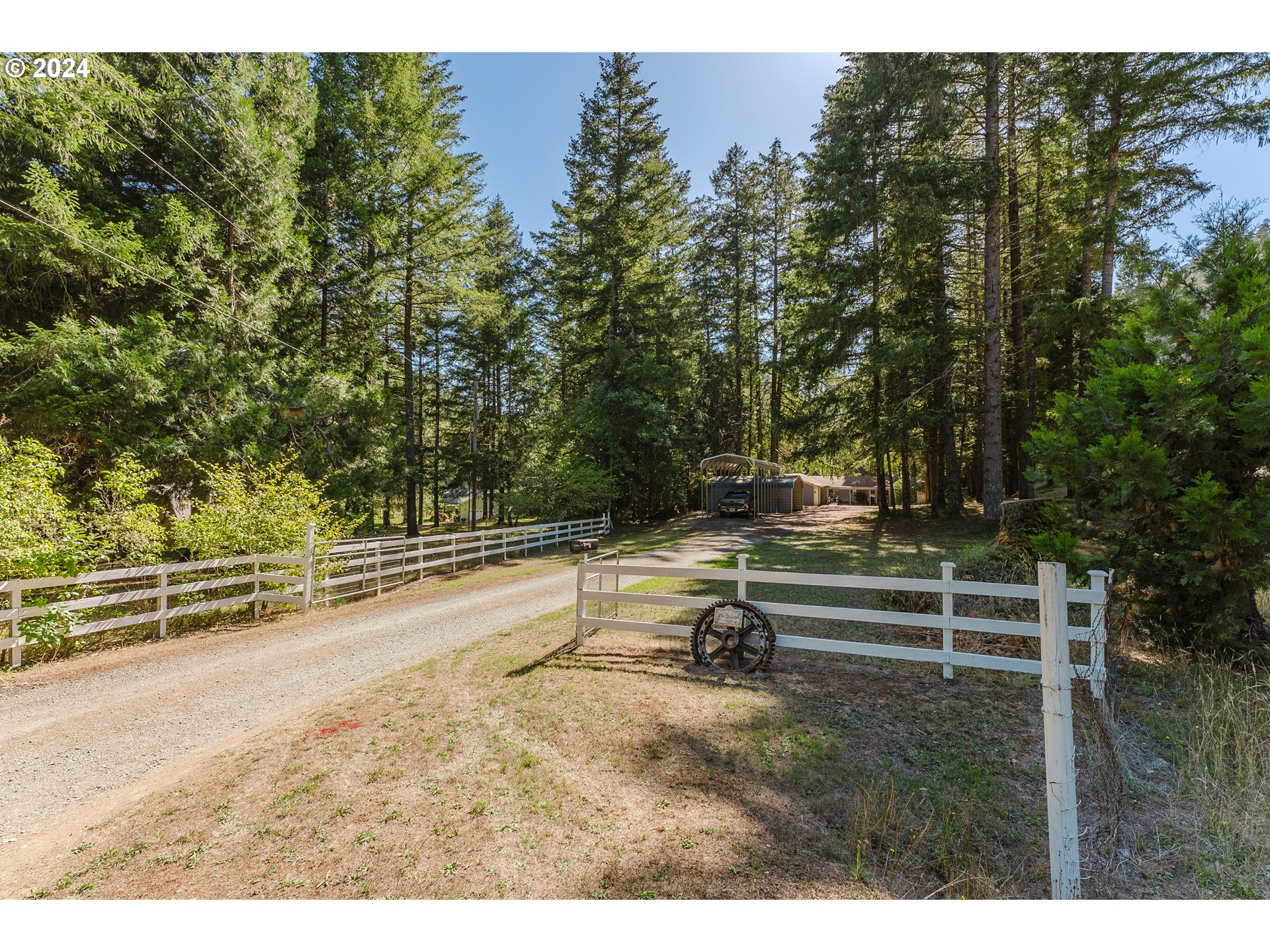 Picturesque, peaceful retreat located on just under four level acres with 600 feet of year round creek frontage. This one level 4 bedroom, 2 bath home with 1720 square feet has new LVP flooring, a detached 864 SF garage, several metal covered carports, a barn, irrigation rights and a beautiful pasture leading to the creek’s edge. The living areas feature an indoor/outdoor family room, Corian counters in the kitchen, pellet stove in the living room and a woodstove in the spacious 4th bedroom.  The primary bedroom and the 4th bedroom as well as the large utility room offer separate exterior entrances. This property is so serene, and is a must see!