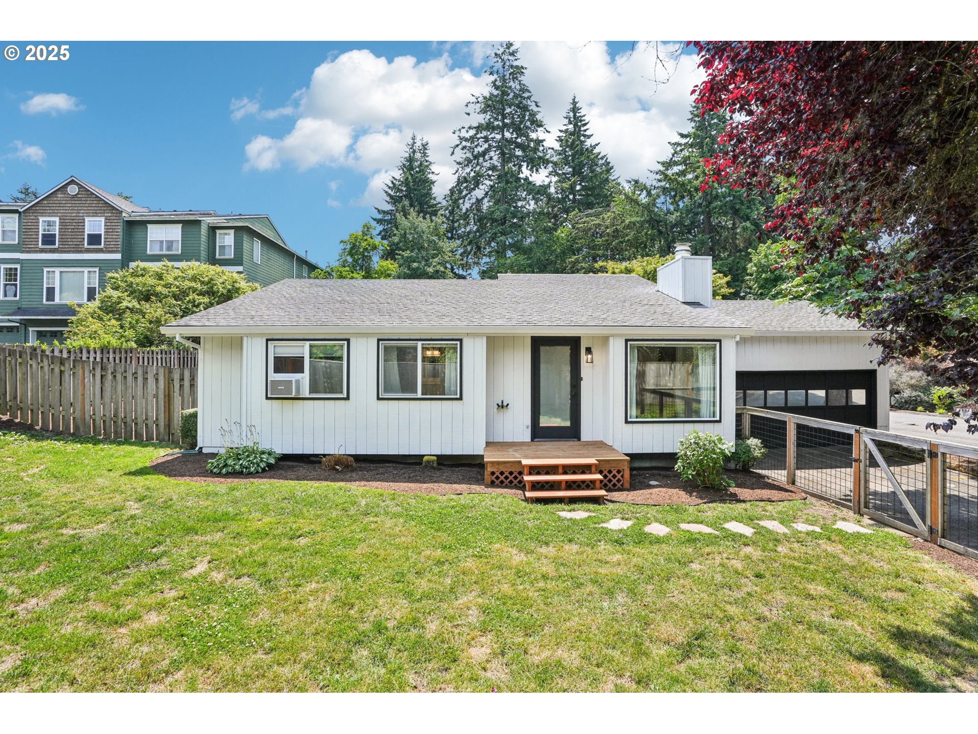 Welcome home to this beautifully updated one-level house on a large corner lot! The home is filled with natural light: windows in all rooms look out on the meticulously landscaped front, side and back yards. Enjoy comfortable living with everything you need: updated kitchen with quartz countertops, stainless steel appliances and tons of storage; a spacious living room with vaulted ceilings and a wood burning fireplace, two comfortable bedrooms on the opposite side of the house; and two bathrooms including an en suite in the primary bedroom. And no details have been overlooked: there are brand new LVP floors throughout the home. Both bedrooms have convenient shelving organizers in the closets. The second bedroom has a custom built-in workspace with shelves, adjustable lighting and a monitor stand. There are top quality window air conditioners in the bedrooms and living room, to keep the house comfortable in all weather. The house is set up for smart living - lights, heating, A/C, front door, and garage door are all configurable to pretty much any smart ecosystem. The bonus living space can be converted back into a third bedroom as per tax records. Outside is an entertainer's paradise! The expansive deck in back has been updated and refinished, as has the front deck. The gorgeous front lawn is fully fenced and lined with trees for privacy from the main road. This amazing home is not to be missed! [Home Energy Score = 2. HES Report at https://rpt.greenbuildingregistry.com/hes/OR10191535]