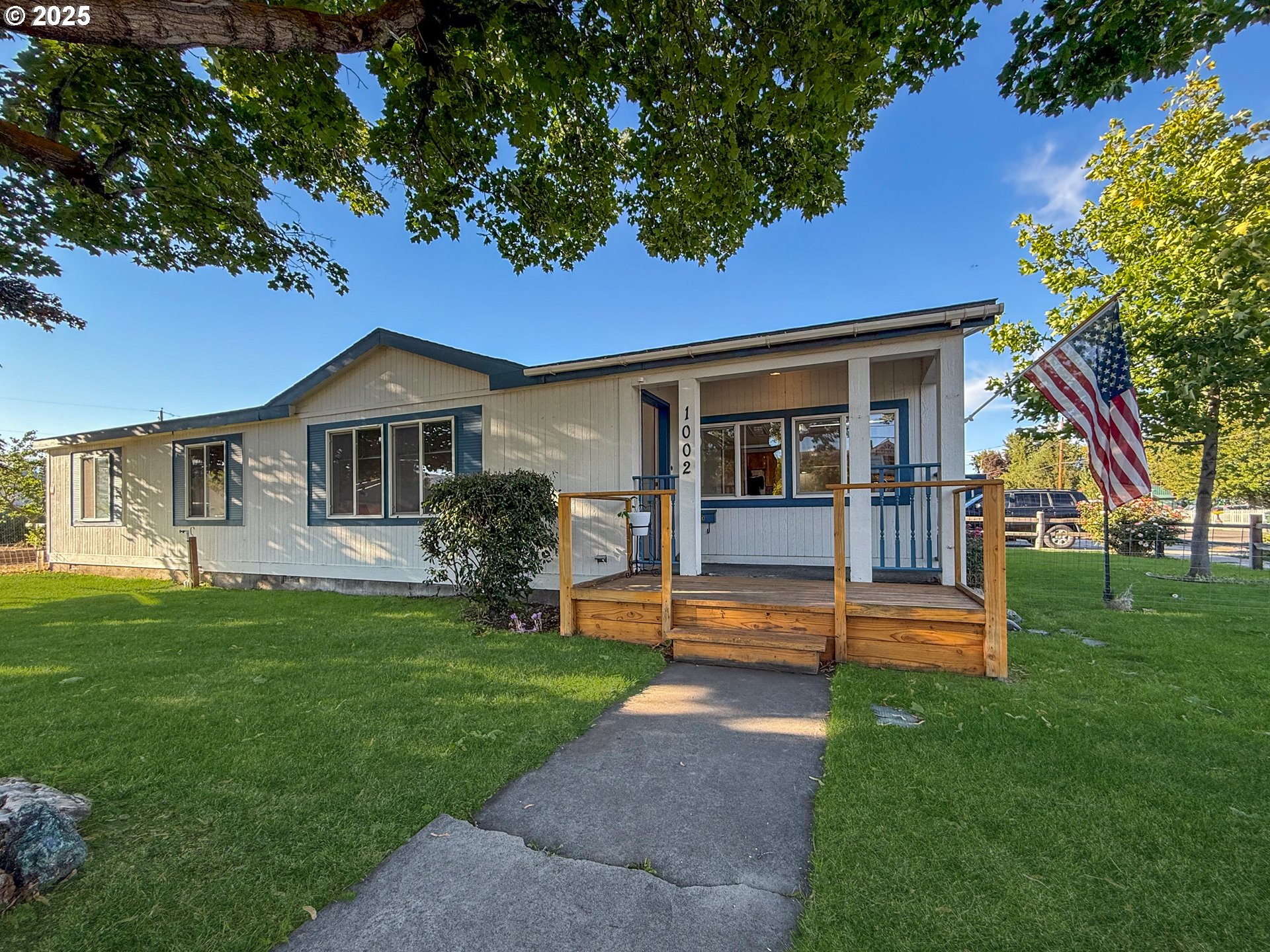 Come see this well-maintained 3-bedroom, 2-bath manufactured home on a spacious corner lot in historic Baker County. Set on a beautifully landscaped property with mature trees and abundant outdoor features, this inviting home offers comfort, functionality, and thoughtful updates throughout. Recent improvements include a newer roof, exterior paint, and a serviced AC unit. Inside, enjoy a practical layout that flows easily for everyday living. Outside, the property shines with a covered front porch, underground sprinklers, and a breezeway connecting the home to the shop area.The detached two-car garage is built with 2x6 construction, fully insulated and dry walled, and includes concrete floors, attic storage, and a 240-amp plug-in—ideal for a workshop or EV charging. The property also includes a greenhouse with full power and control panel, an irrigation well, grape arbor, 2 apricot trees, 2 plum trees, and a variety of seasonal perennials including irises, tulips, and daffodils.Bonus features: a gas water heater, and a charming barn dating back to ~1926, recently updated with a metal roof. Located in a quiet neighborhood offering the best of peaceful, small-town living with plenty of space to grow.